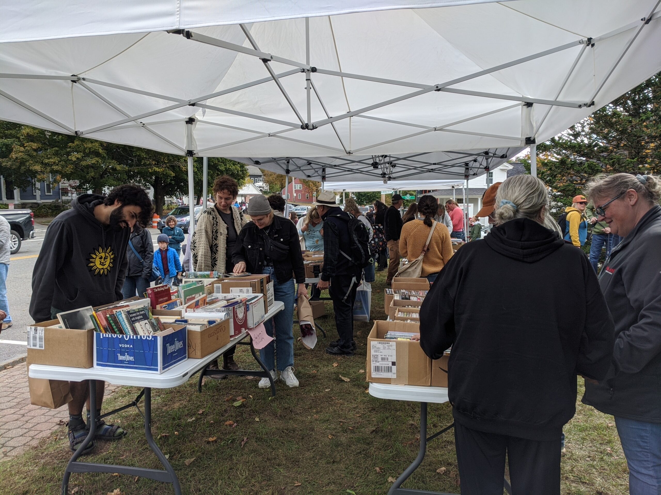 people browsing books under tent canopy